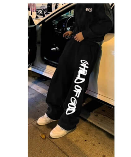 Pantalones holgados streetwear para hombres en color negro con diseño 'Child of God'.